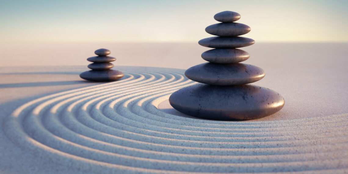 Japanese ZEN garden with textured sand waves and stack of stones
