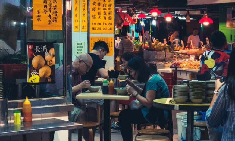 People eating in outdoor street food restaurant in Hong Kong at night